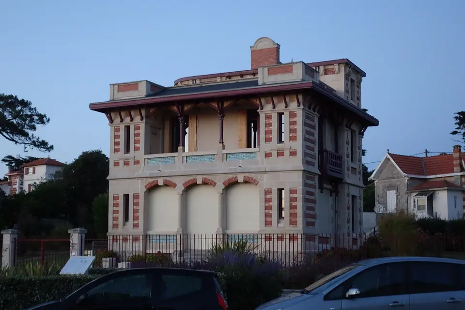 Villa Plaisance à Lacanau-Océan, maison balnéaire en pierre et briques avec loggia à l'étage, corniche décorée et jardin clos.